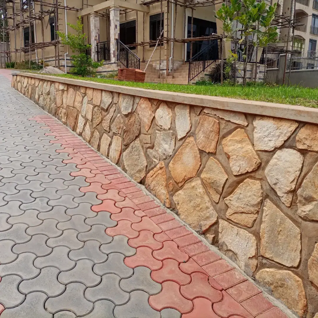 The paved route runs beside a stone-faced edge and raised green space.
