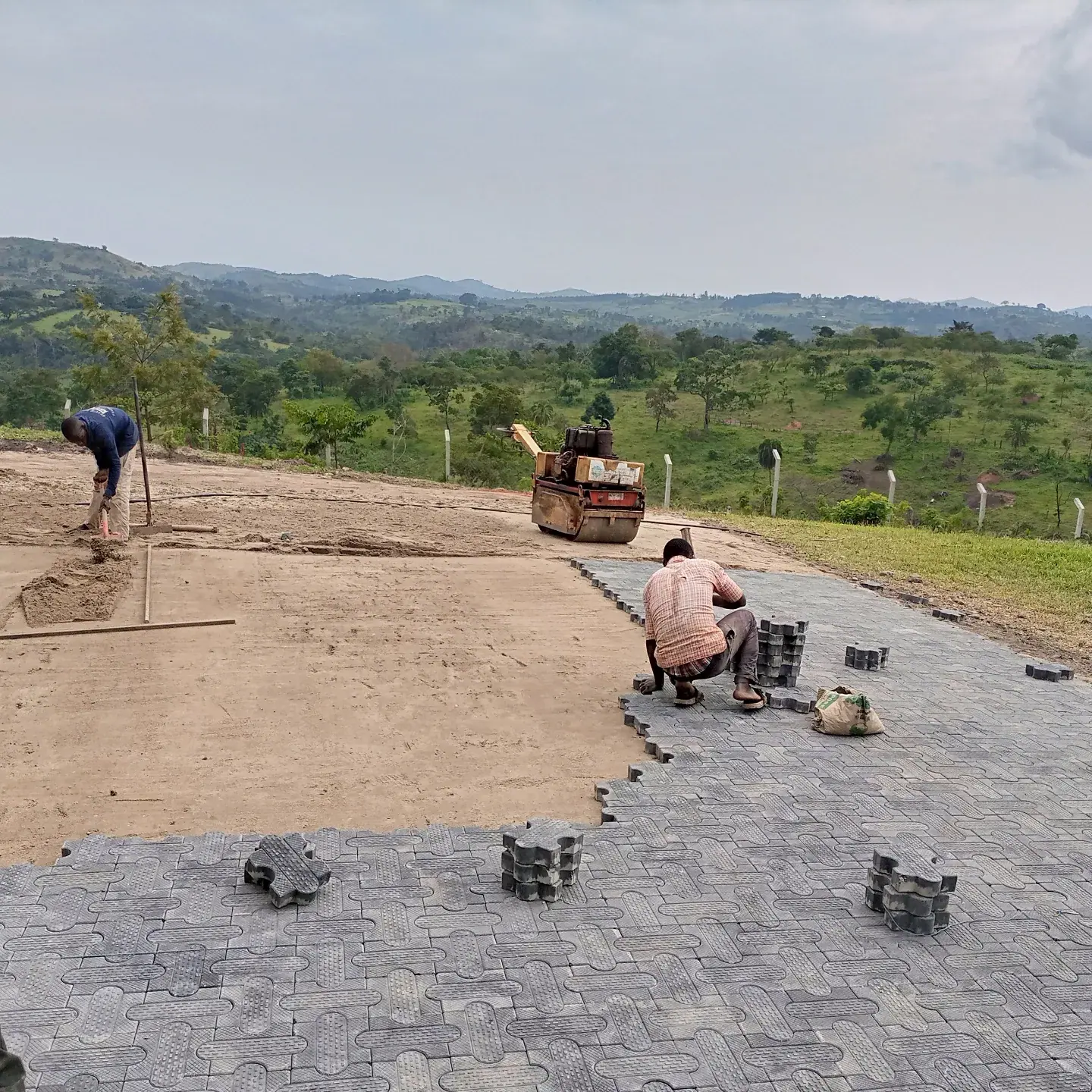Pavers being laid along the edge of the arrival.