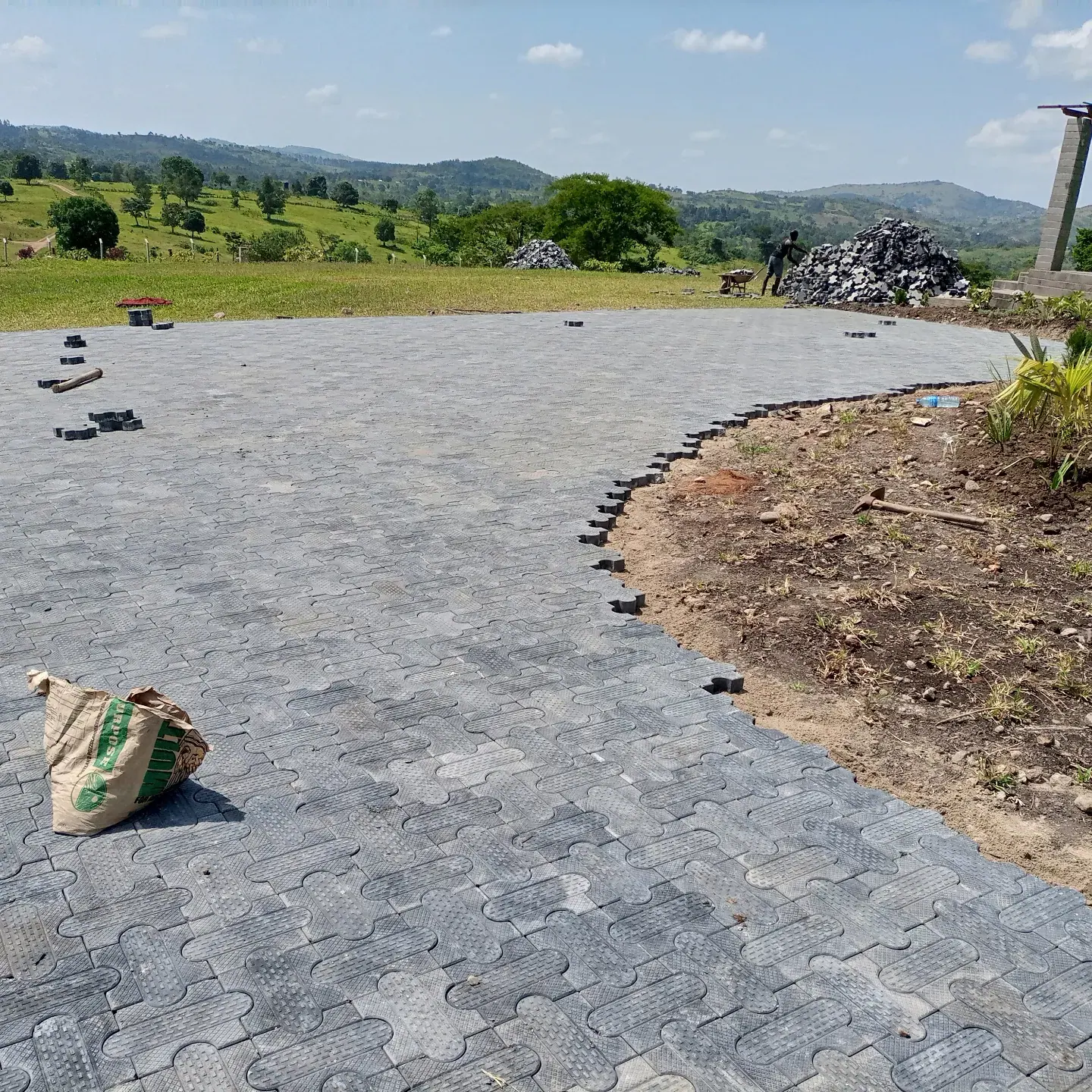 The paved curve takes shape beside an open planting bed.
