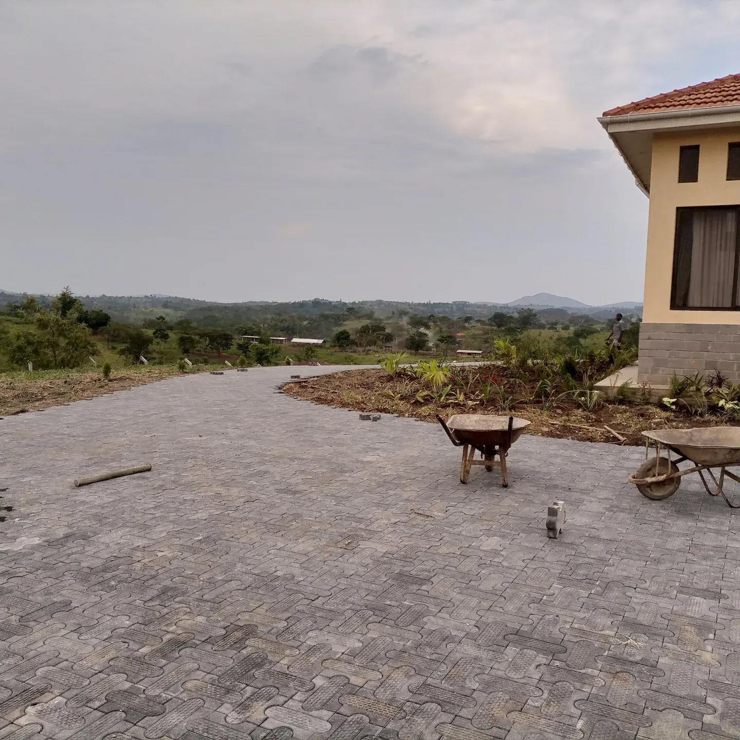 Paving work alongside the house, with tools still on site.